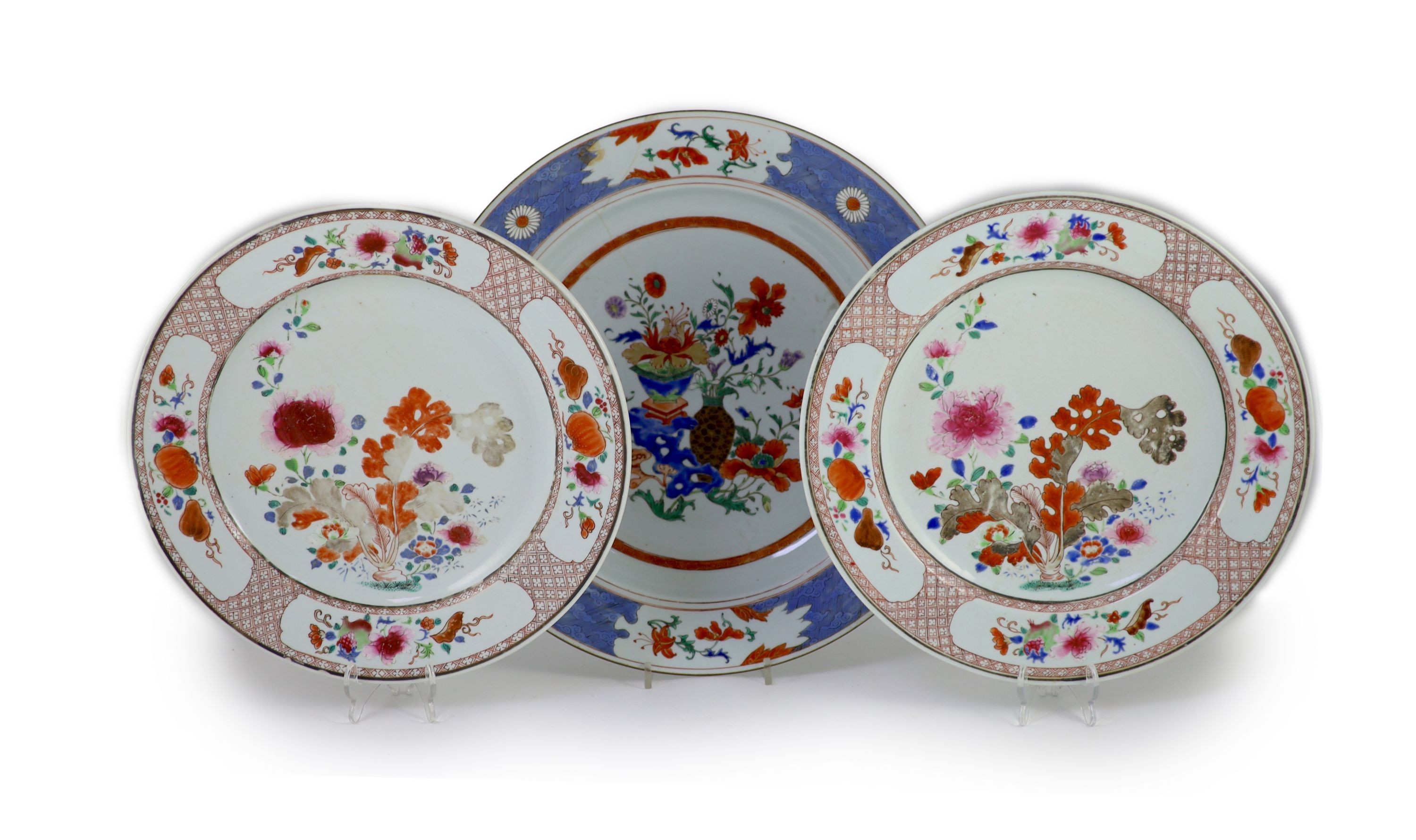 A pair of Chinese export famille rose dishes and a similar charger, early Qianlong period, diameter 35 cm and 42 cm, the charger broken and repaired